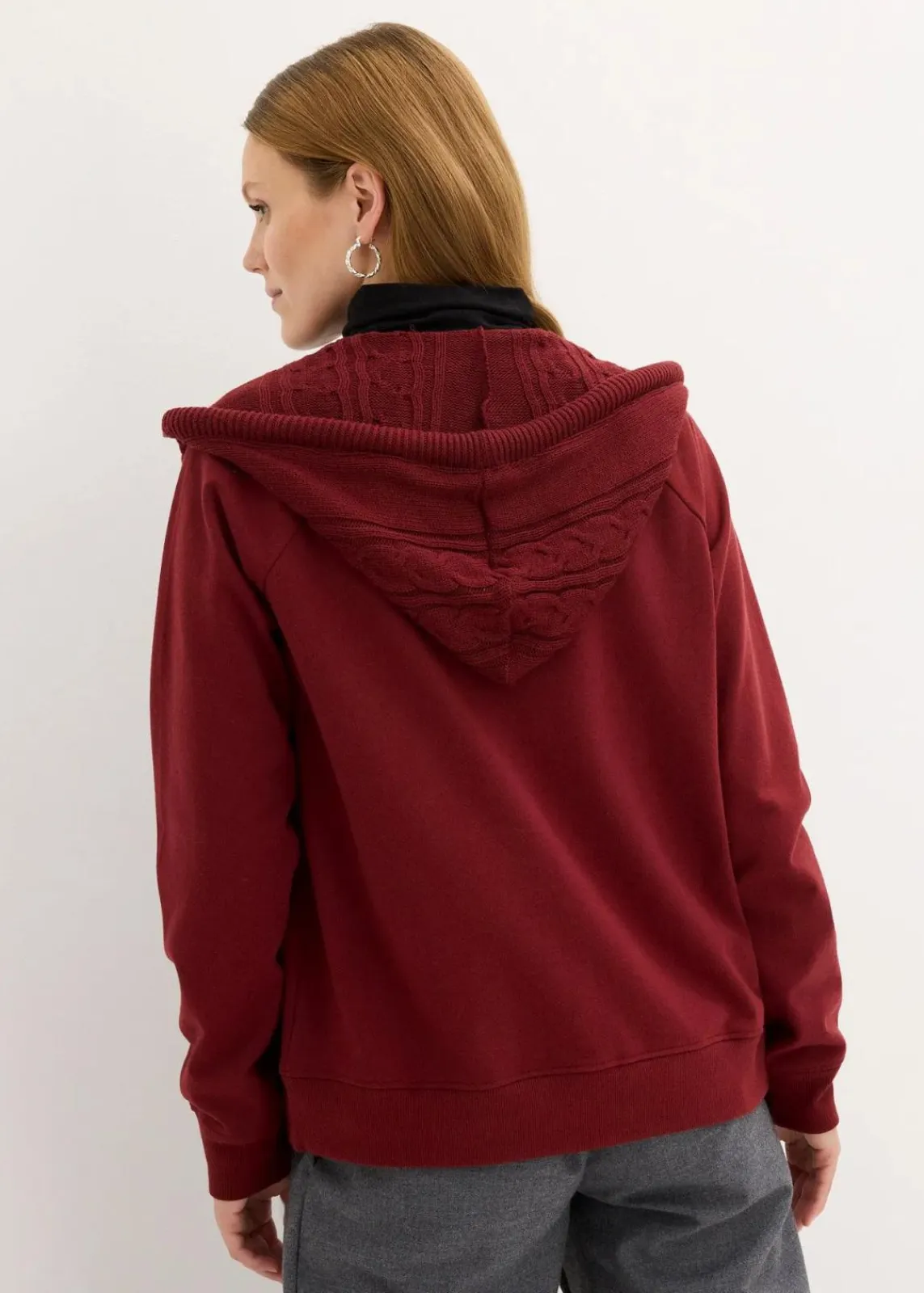 bonprix Sweat|Nachhaltigere Materialien^Sweatjacke mit Strickkapuze und Tasche rubinrot